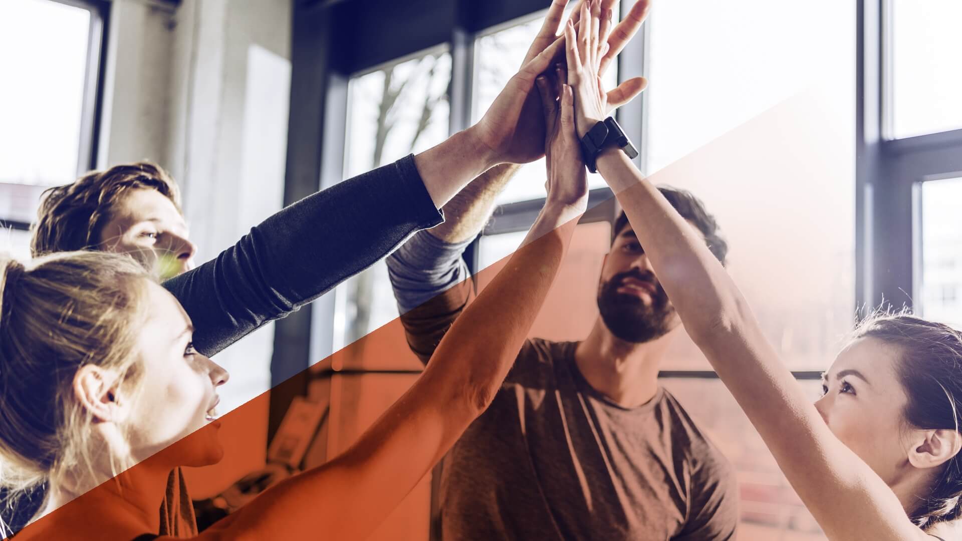 Gruppe von jungen Menschen gibt sich ein High-Five.