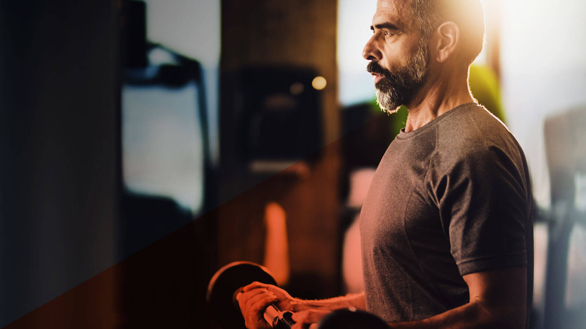 Älterer Herr mit Hantel im Training