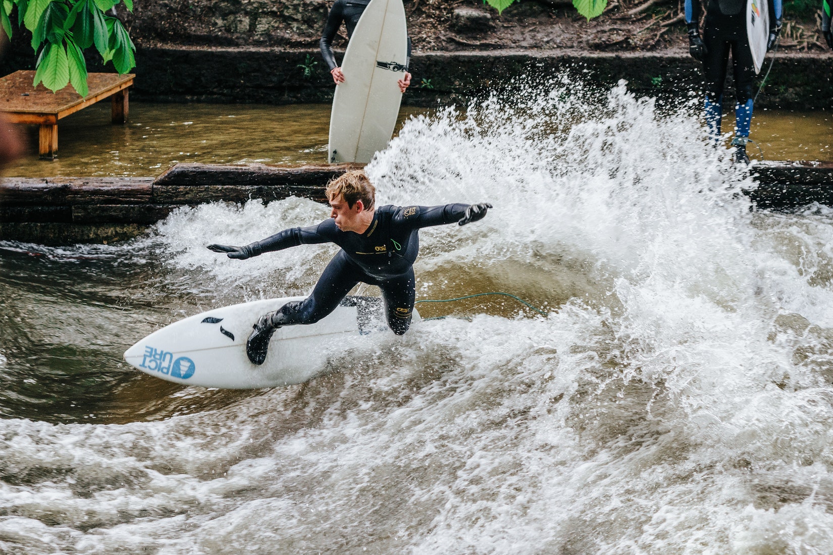 Ein Bild von einem Surfer auf der Eisbachwelle in München im Neoprenanzug